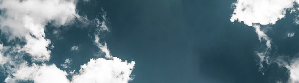 A deep blue sky with bright white clouds.