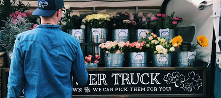 A man standing in front of a flower truck.