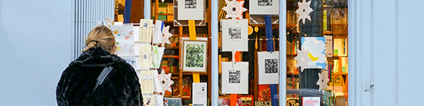 A woman standing in front of holiday marketing flyers.